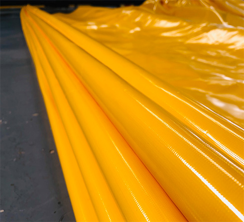 Rolls of bright yellow flood barrier material