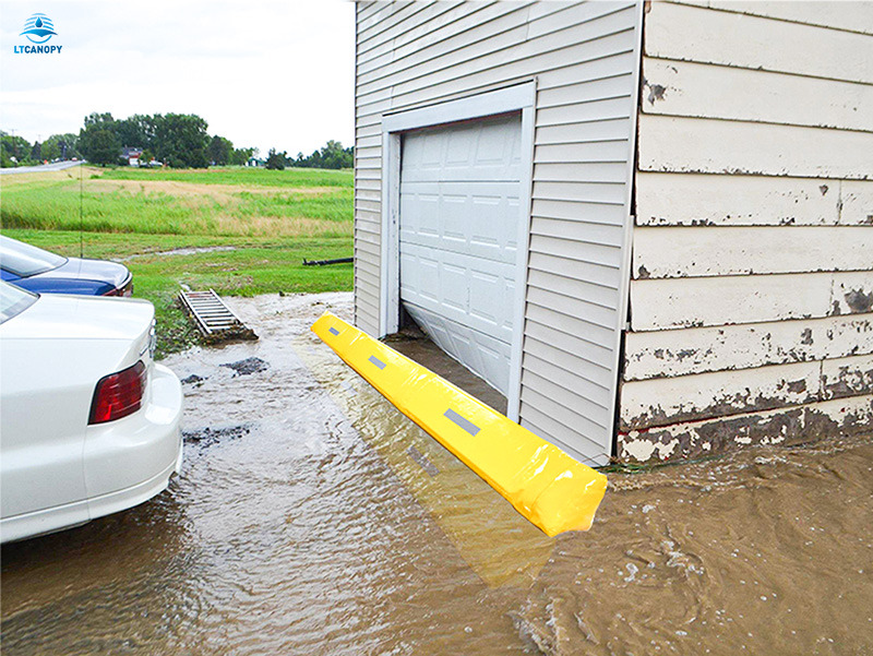 Yellow PVC flood barrier blocks muddy floodwater at garage doorway