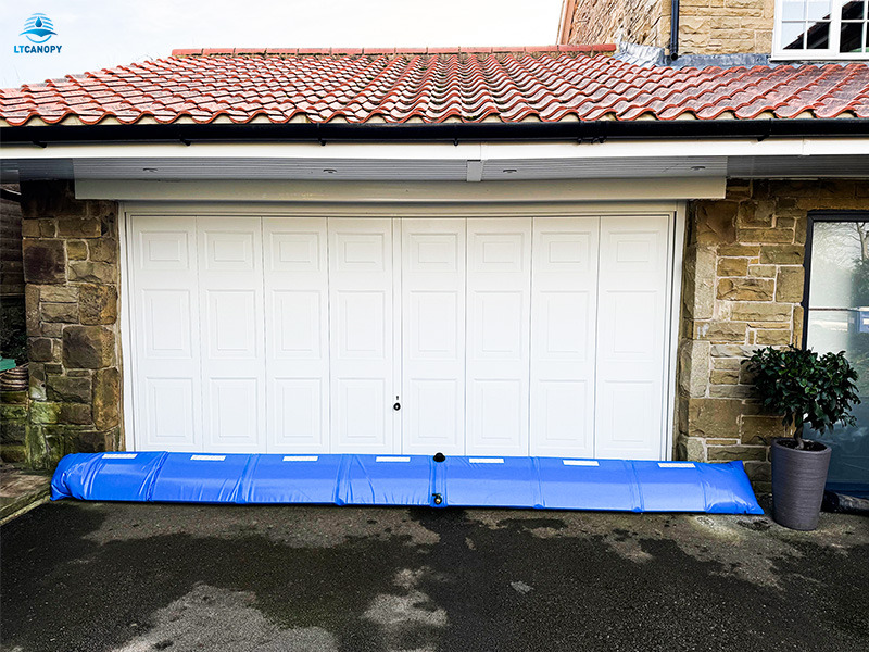 Blue PVC flood barrier set in front of residential garage for flood defense